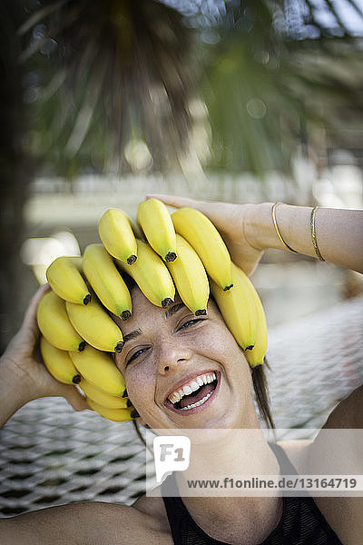Portrait of young woman at beach with bananas on head  Islamorada  Florida  USA