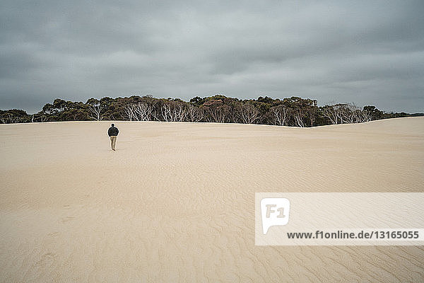 Mature man walking on sand dunes  Tasmania