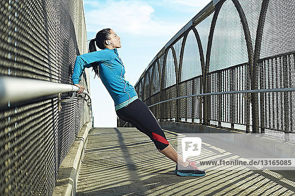 Mid adult woman stretching on bridge