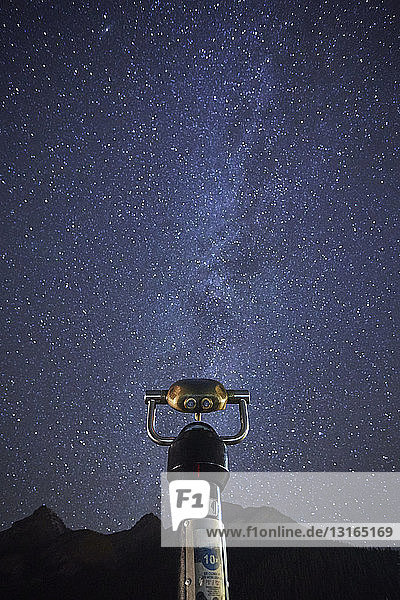 Viewing binoculars against starry sky beside Lake Louise Alberta Canada
