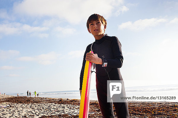 Junge mit Surfbrett am Strand  Encinitas  Kalifornien  USA