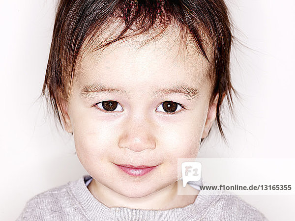 Nahaufnahme des Studioporträts eines lächelnden männlichen Kleinkindes