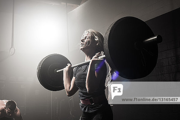 Young woman lifting barbell