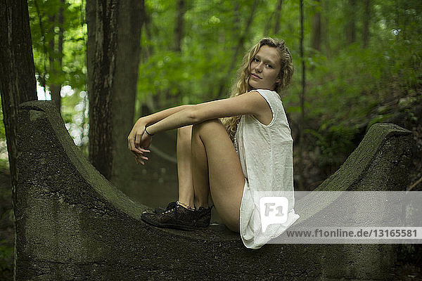 Teenager-Mädchen posiert auf Ruinen in Wäldern