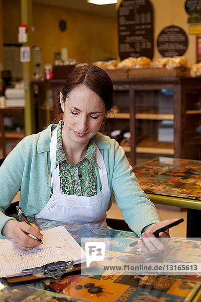 Woman working on accounts at bakery