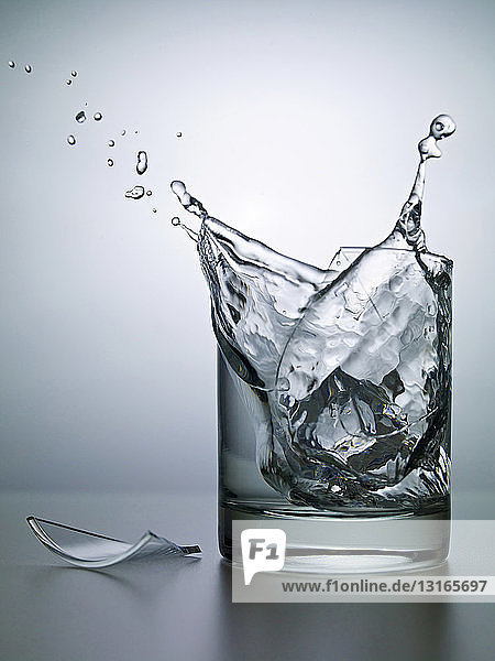 Eiswürfel zerbrechendes Wasserglas