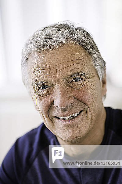 Porträt eines grauhaarigen älteren Mannes  der lächelnd in die Kamera schaut