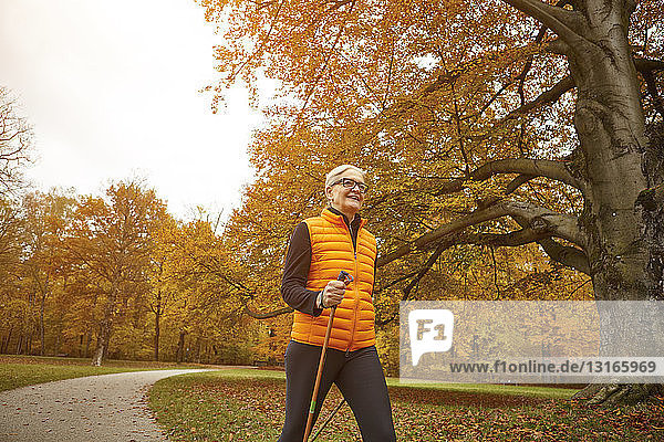 Senioren-Nordic-Walkerin beim Schreiten im Herbstpark