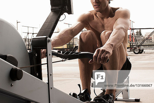 Mann benutzt Trainingsgeräte im Fitnessstudio