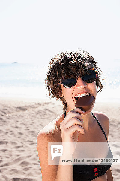 Frau isst Eiscreme am Strand