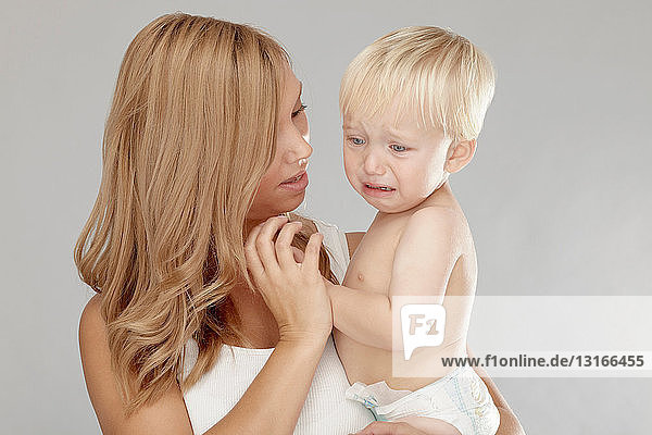 Mother holding crying baby boy