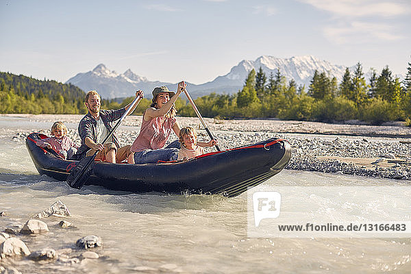 Family using paddles to steer dinghy on water  Wallgau  Bavaria  germany