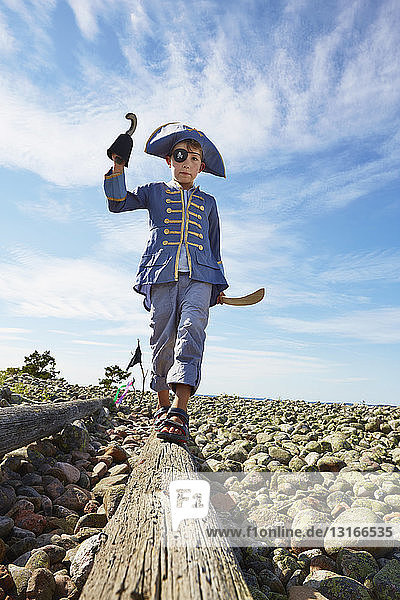 Junge als Pirat verkleidet auf Baumstamm am Strand  Eggegrund  Schweden