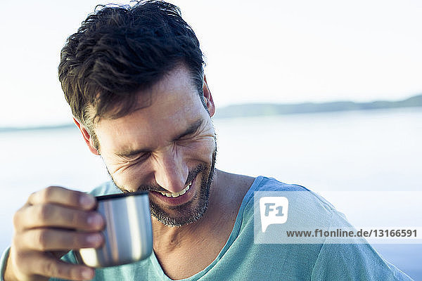 Reifer Mann mit Kaffee lachend