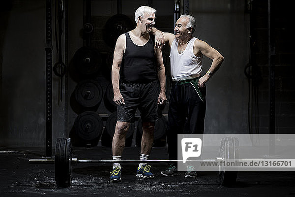 Ältere Männer unterhalten sich in dunkler Turnhalle