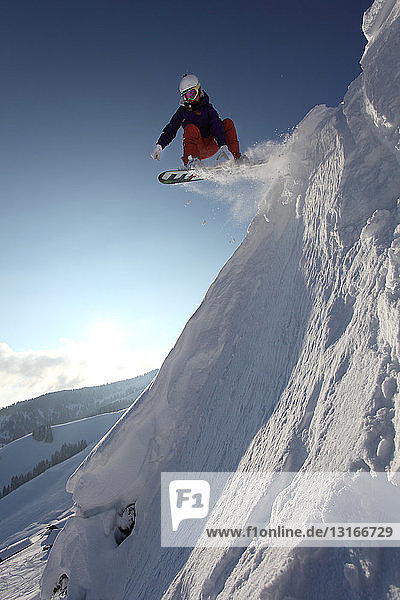 Snowboarder springt den Berg hinunter