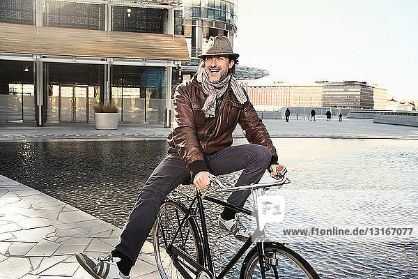 Mittelgroßer erwachsener Mann genießt Fahrradfahren in der Stadt