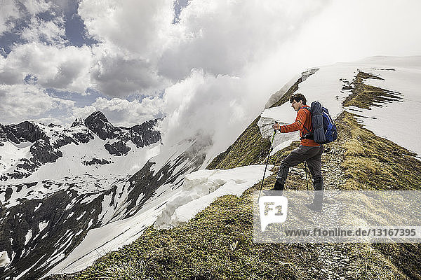 Junger männlicher Bergwanderer mit Blick vom Bergrücken in den Bayerischen Alpen  Oberstdorf  Bayern  Deutschland