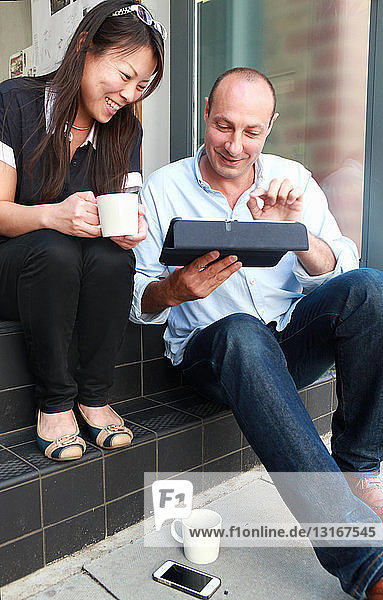 Zwei Architektenkollegen schauen auf das digitale Tablett auf der Bürostufe