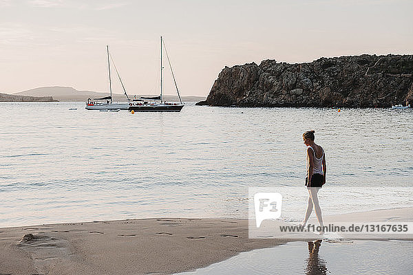 Mid adult woman strolling on beach  Menorca  Balearic islands  Spain
