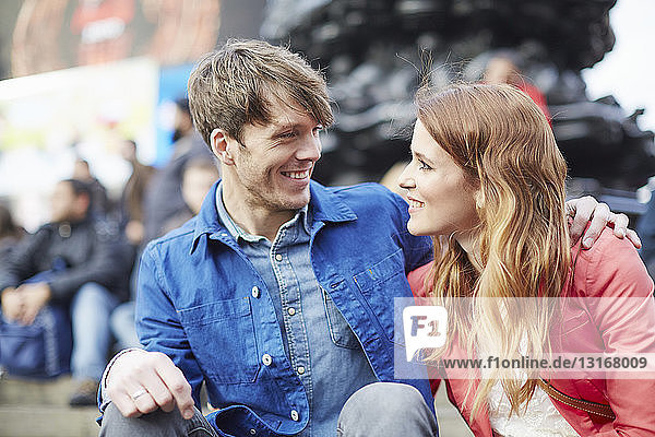 Tourist couple sitting at Piccadilly Circus  London  UK