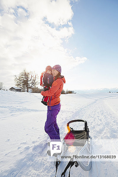 Porträt einer mittleren erwachsenen Frau  die einen kleinen Jungen trägt  Dolomiten  Eisacktal  Südtirol  Italien