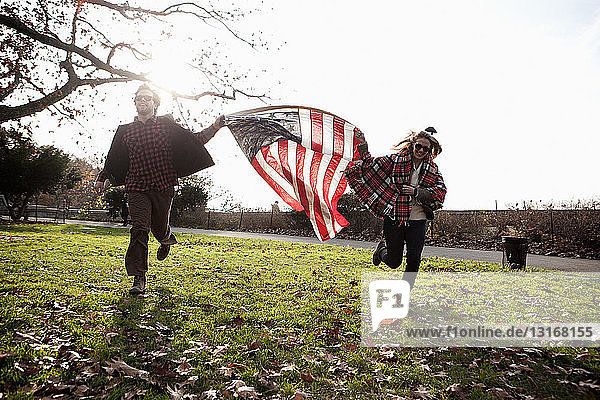 Freunde laufen mit amerikanischer Flagge