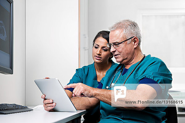 Doctors looking at digital tablet