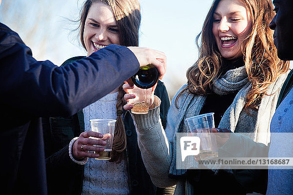 Junge erwachsene Freunde genießen Weißwein im Freien