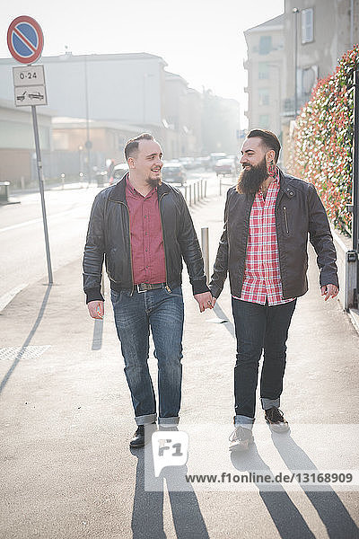 Schwules Paar geht Hand in Hand auf der Straße