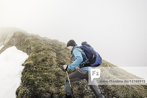 Bergtrekking junger Mann in Schnee und Nebel  Bayerische Alpen  Oberstdorf  Bayern  Deutschland