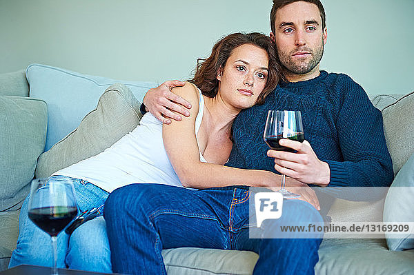 Couple enjoying wine on sofa