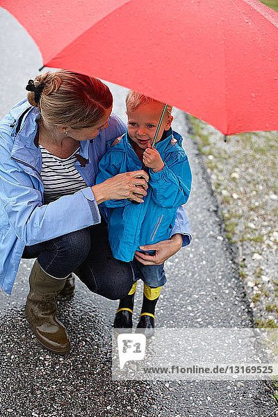 Mutter und Sohn mit Regenschirm unterwegs