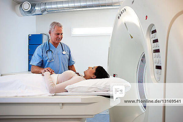 Arzt beruhigt Patient vor CT-Untersuchung