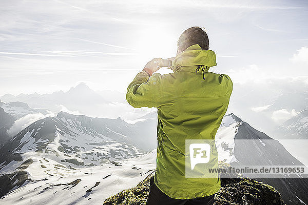 Junger männlicher Bergwanderer beim Fotografieren in den bayerischen Alpen  Oberstdorf  Bayern  Deutschland
