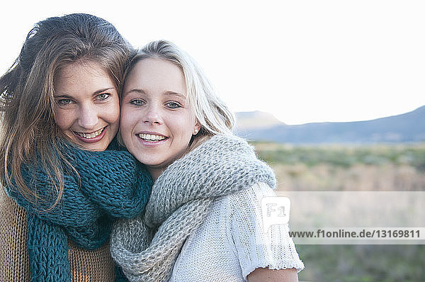 Two young women wearing knitted scarf