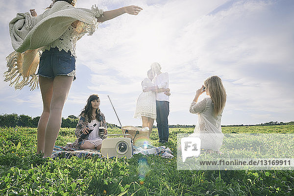 Fünf junge erwachsene Freunde machen ein Picknick auf dem Feld