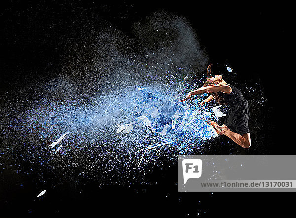 Tänzerin in der Luft mit blauer Pulverexplosion
