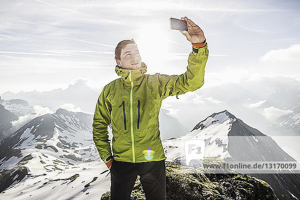 Junger männlicher Bergwanderer beim Smartphone-Selfie in den bayerischen Alpen  Oberstdorf  Bayern  Deutschland