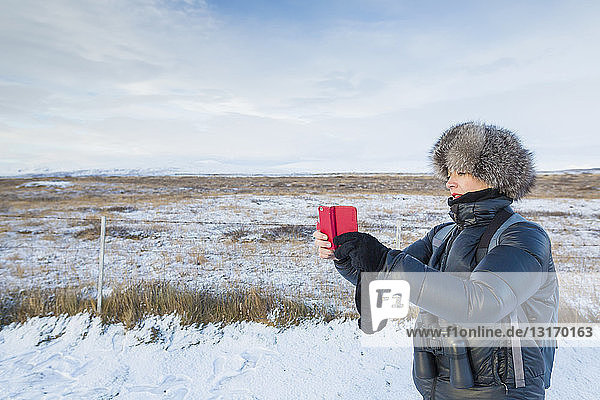 Reife Frau fotografiert auf schneebedecktem Feld  Island