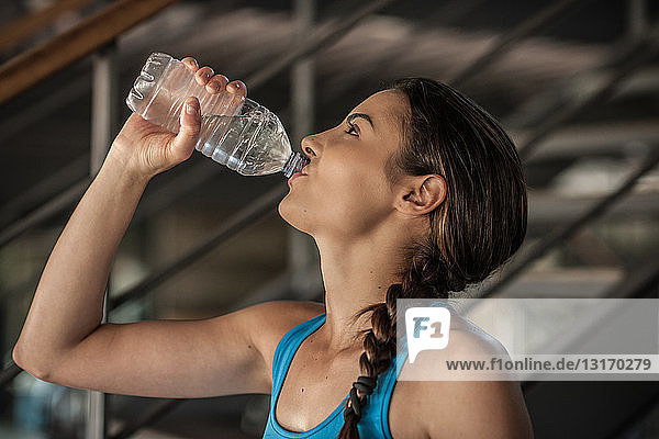 Junge Frau trinkt Wasser aus der Flasche