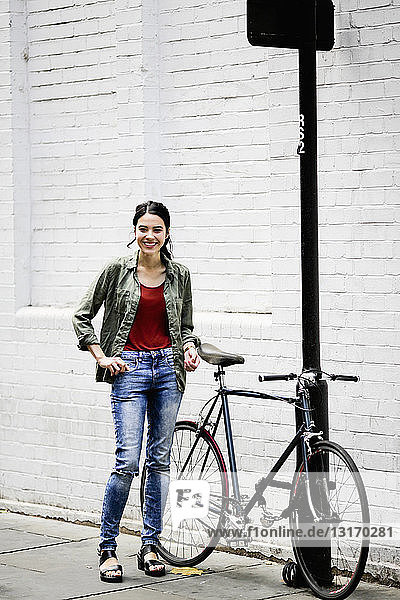 Woman standing beside bicycle