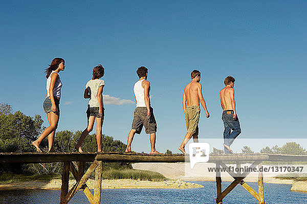 Group of young people walking on jetty