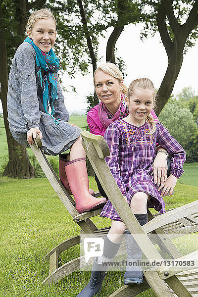 Mutter und Töchter auf Holzstuhl sitzend  Porträt