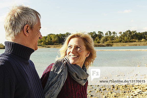 Mature couple beside lake  smiling