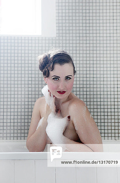 Junge Frau in der Badewanne  von Blasen bedeckt
