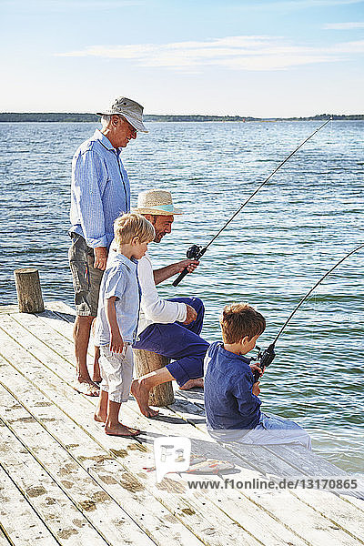 Boys with father and grandfather fishing  Utvalnas  Sweden