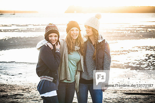 Porträt von drei jungen erwachsenen Frauen am Strand