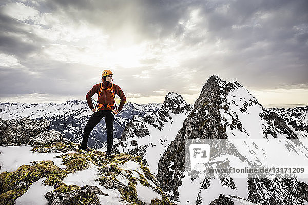 Young hiker standing on mountain range  looking away  Kellenspitze  Tannheim mountains  Tyrol  Austria