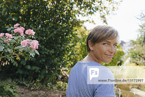 Portrait of smiling woman in garden turning round